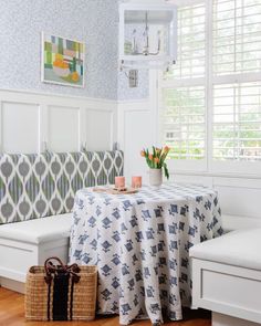 a white bench with a blue table cloth on it and a basket next to it