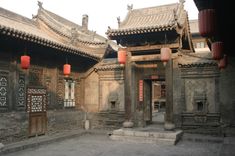 an old building with lanterns hanging from it's roof