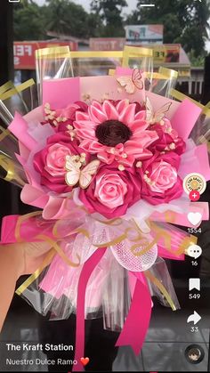 a pink flower bouquet is being held by someone's hand on the phone screen