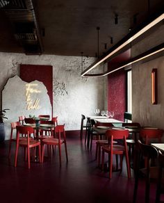 an empty restaurant with red chairs and tables