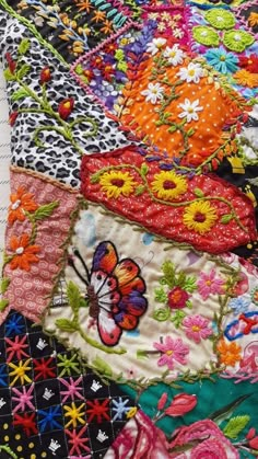 the colorful quilt has many different designs on it's sides, including butterflies and flowers