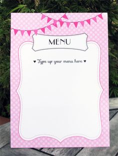 a pink and white menu card with buntings on the top, sitting on a table