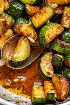 cooked zucchini and potatoes in a pan with a spoon on the side, ready to be eaten