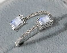 an open ring with two square cut stones on it