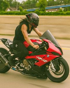 a woman riding on the back of a red motorcycle