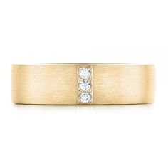 a yellow gold wedding ring with three diamonds