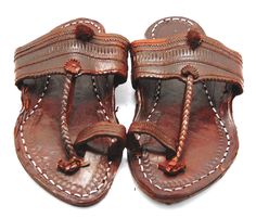 Check out our brand-new, genuine handcrafted Kolhapuri sliding sandals from India, high-quality leather sandals with an ethnic Indian toe strap that are incredibly comfortable and simple to use. The leather is prepared in such a way that it has no allergenic characteristics at all and feels light, smooth, and silky. Hand stitching and punching are being used. These unisex slippers are ideal for everyday use as well as for any formal event. We offer various different shoe styles. For more of our selection, visit our page! We send packages to you promptly and well packaged for a safe journey. We appreciate your support of our little business. Shipped from the USA. Traditional Brown Toe Post Flip Flops, Traditional Leather Flip Flops For Festivals, Traditional Leather Sole Flip Flops For Beach, Traditional Sandals With Leather Sole For Vacation, Traditional Leather Sole Sandals For Vacation, Traditional Vacation Sandals With Leather Sole, Traditional Leather Flip Flops With Single Toe Strap, Traditional Closed Toe Mules For Festivals, Traditional Handmade Brown Flip Flops