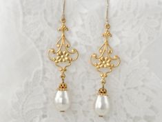 Delightfully eclectic and with an Art Nouveau flair, these earrings are delicate gold floral filigree are embellished with white Swarovski crystal pear shaped pearl dangles. They are the perfect wedding event or elopement earrings. They make for fabulous gifts for the bride, mother of the bride, or bridesmaids. Finished with 14K Gold-Filled ear wires, these are the perfect earring for sensitive ears, and for wowing the eyes. *Handcrafted design *Delicate silver finish over filigree *Crystal pear White Dangle Bridal Earrings With Intricate Design, White Bridal Dangle Earrings With Intricate Design, White Bridal Earrings With Intricate Dangle Design, Ornate White Pearl Drop Earrings, Elegant Gold Flower Earrings For Wedding, White Intricate Design Pearl Drop Earrings, Vintage Dangle Flower Earrings For Wedding, Classic Yellow Gold Flower Earrings For Wedding, Delicate Gold Earrings With Elegant Design