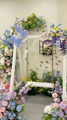 a white bench surrounded by flowers and butterflies