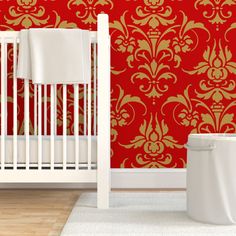 a white crib in front of a red wallpaper