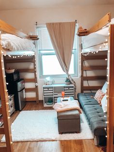 a living room with bunk beds and lights on the wall above them, in front of a window