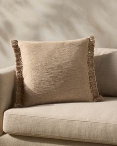 a beige couch with two pillows on it