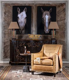 two horse heads are on the wall above a chair and table in front of a fireplace