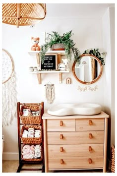 a bathroom with a dresser, mirror and shelf filled with baby items on it's side