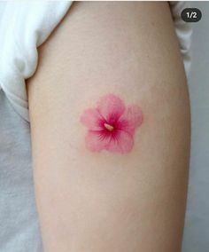 a small pink flower on the back of a woman's thigh