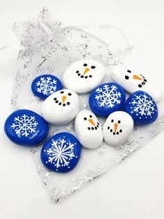 snowmen are painted on rocks in blue and white