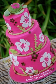 a three tiered pink cake with flowers on it