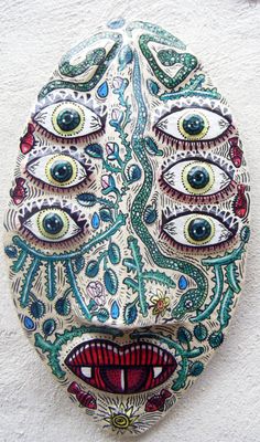 an artistically painted mask hanging on the wall