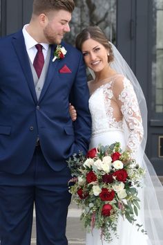 a bride and groom standing together in front of a building