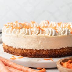 a carrot cake with whipped cream and orange zest toppings on a white plate