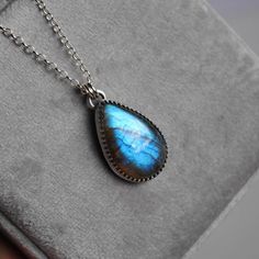 This handmade sterling silver necklace features a beautiful labradorite stone set in a unique bezel. The face of the pendant measures approximately 1 x 0.68 inches.  Choose your chain length and finish (see last photo) from the drop down menus.    ★ All orders come wrapped in a gift box, ready for gifting ★ Silver Labradorite Teardrop Pendant Jewelry, Labradorite Jewelry With Bezel Setting As Gift, Labradorite Jewelry With Bezel Setting For Gift, Silver Labradorite Teardrop Necklace, Labradorite Cabochon Pendant Necklace, Silver Labradorite Teardrop Pendant Necklace, Labradorite Necklace, Labradorite Jewelry, Labradorite Necklaces