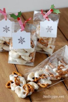 three bags filled with pretzels sitting on top of a wooden table