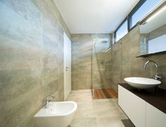 a bathroom with a sink, mirror and glass shower stall in the middle of it