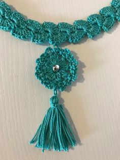 a crocheted necklace with tassels and beads