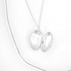 Elevate your style with the Roma Oval Locket Necklace in elegant sterling silver. Carry your most treasured memories close to your heart with this exquisite piece. With its timeless design, it's the perfect accessory for any occasion. *ALSO AVAILABLE IN GOLD PRODUCT DETAILS Necklace Length: 17" + 3" Extension Locket Size: 7/8" L x 11/16" W Material: .925 Sterling Silver Finish: Rhodium (anti-tarnish) Closure: Lobster Claw Luxury Silver Oval Pendant Locket Necklace, Locket Necklace Silver, Oval Locket Necklace, Silver Locket Necklace, Oval Locket, Detailed Necklace, Locket Necklace, Necklace Length, Necklace Silver