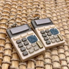 pair of calculator earrings on woven surface