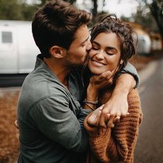 a man and woman hugging each other on the street