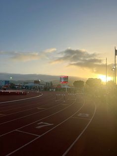 the sun is setting over an empty track