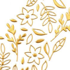 some gold metal flowers and leaves on a white background