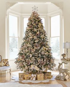 a decorated christmas tree in a living room with presents on the floor next to it