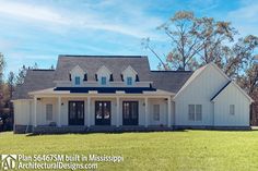 a large white house sitting on top of a lush green field