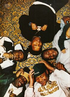 a group of young men laying on top of each other in front of a rug