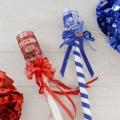 two red, white and blue pom poms are on the floor next to a tube of booze