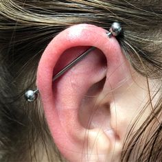 a close up of a person's ear with some piercings on it