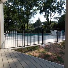 a fenced in area next to a swimming pool