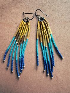 Vintage and new vibrant blue and amber glass seed beads  beaded into tassels. Finished with niobium brown allergy free earwires . 3.5" long Blue Tassel Earrings With Round Beads, Turquoise Tassel Earrings With Dangling Beads, Bohemian Blue Long Drop Beaded Earrings, Adjustable Blue Tassel Earrings With Colorful Beads, Blue Bohemian Tassel Earrings With Round Beads, Blue Bohemian Tassel Earrings With Dangling Beads, Adjustable Blue Beaded Fringe Earrings, Blue Bohemian Beaded Fringe Tassel Earrings, Blue Long Drop Tassel Jewelry