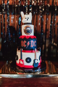 a three tiered cake is decorated with music instruments and an ac / dc logo