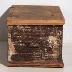 an old wooden box sitting on top of a white floor