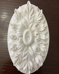 a white decorative object sitting on top of a wooden table