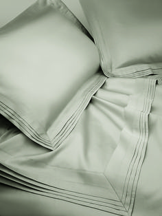 the sheets and pillow cases are neatly folded on top of each other in black and white