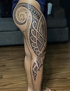 a woman's legs with tattoos on them are shown in front of a couch