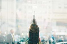 there is a large clock tower seen through the window in this cityscape photo