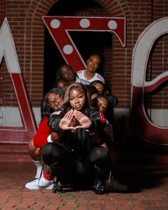 a group of people posing for a photo in front of a sign with the number seven on it