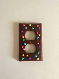 a chocolate light switch plate with multi colored candies on it