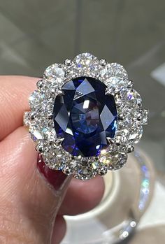 Blue sapphire statement cocktail ring is a great way to create an elegant, princess-like look.The center stone is oval in shape and has gorgeous facets. For extra sparkle, it has been framed by 1.34 round diamonds forming a beautiful halo around.Metal: 18K White GoldDiamond Weight : 2.43ct twBlue Sapphire Weight: 5.09ctWidth: 18 mm X 17mm Luxury Sapphire Oval Halo Ring, Dazzling Oval Sapphire Diamond Ring, Luxury Oval Sapphire Halo Ring, Dazzling Sapphire Diamond Ring, Oval Shape, Dazzling Sapphire Oval Diamond Ring, Luxury Blue Oval Cluster Ring, Luxury Blue Oval Halo Ring, Dazzling Oval Sapphire Ring With Brilliant Cut, Dazzling Blue Oval Diamond Ring