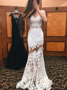 a woman taking a selfie in front of a mirror wearing a white lace dress